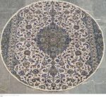 A detailed, elegant Kashan Persian rug with a central medallion on a crimson field